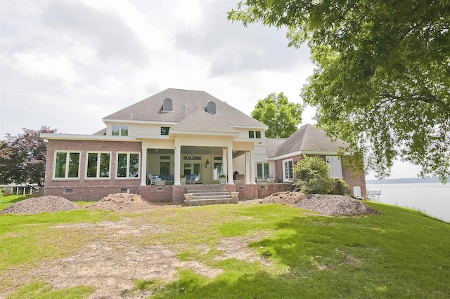 rear view of house featuring a lawn, brick siding, and crawl space