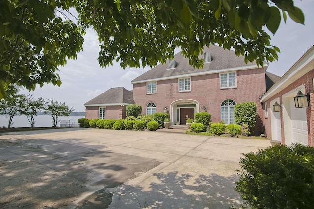 colonial home featuring brick siding and driveway