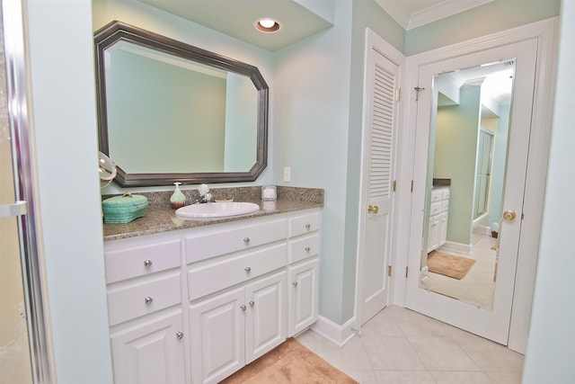 bathroom featuring crown molding, baseboards, tile patterned flooring, and vanity