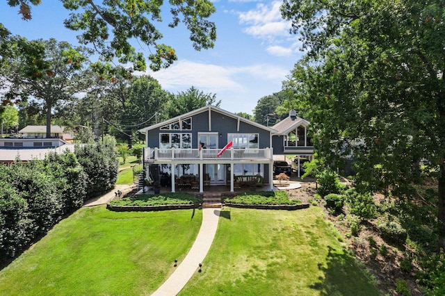 rear view of house with a balcony, a patio area, and a lawn