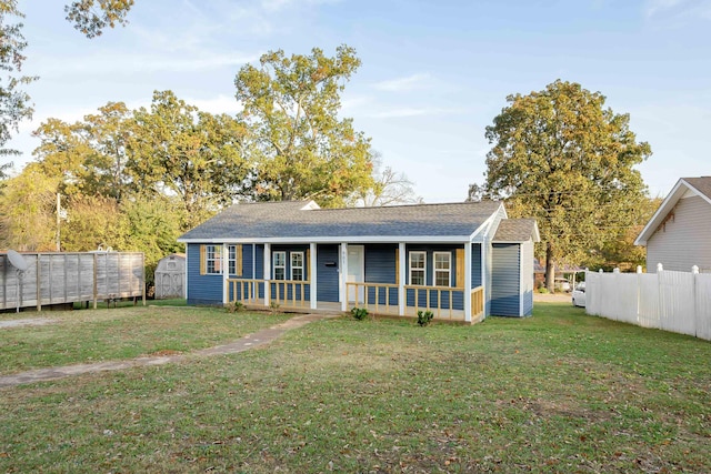 ranch-style home with a front yard, a storage shed, and covered porch