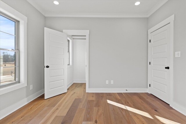 unfurnished bedroom featuring ornamental molding and light hardwood / wood-style floors