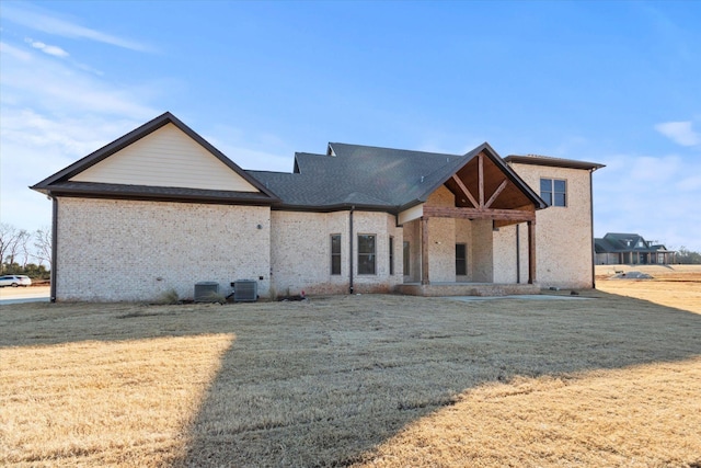 view of front of home featuring central AC and a front lawn