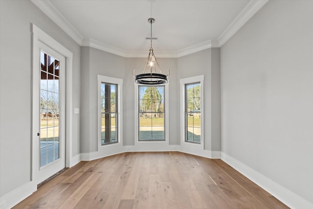 unfurnished dining area featuring crown molding, a healthy amount of sunlight, and light wood-type flooring