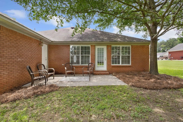 - back of house featuring brick siding, a patio area, and a yard