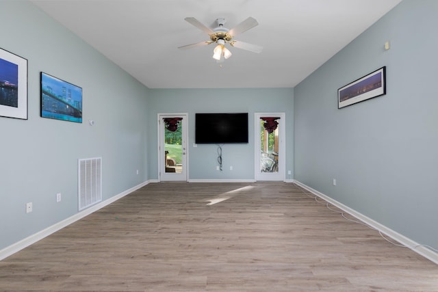 unfurnished living room with light wood-style floors, visible vents, baseboards, and a ceiling fan