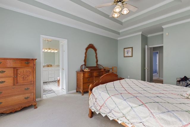 bedroom with ensuite bath, a tray ceiling, ornamental molding, and light colored carpet