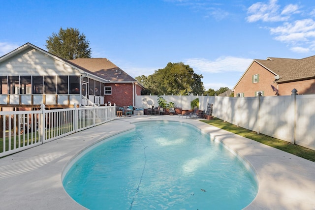 view of pool with a fenced backyard, a sunroom, and a fenced in pool