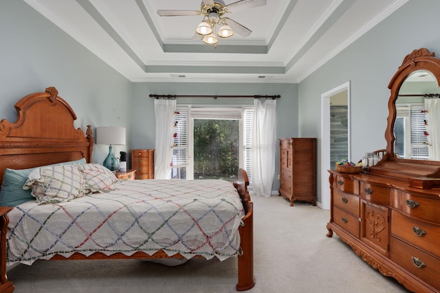 bedroom featuring a tray ceiling, crown molding, light colored carpet, visible vents, and a ceiling fan