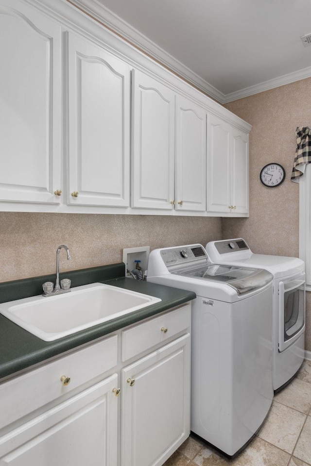 laundry room with crown molding, cabinet space, stone finish flooring, a sink, and washer and dryer