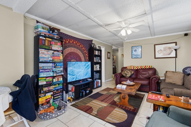 tiled living area with a drop ceiling and ceiling fan