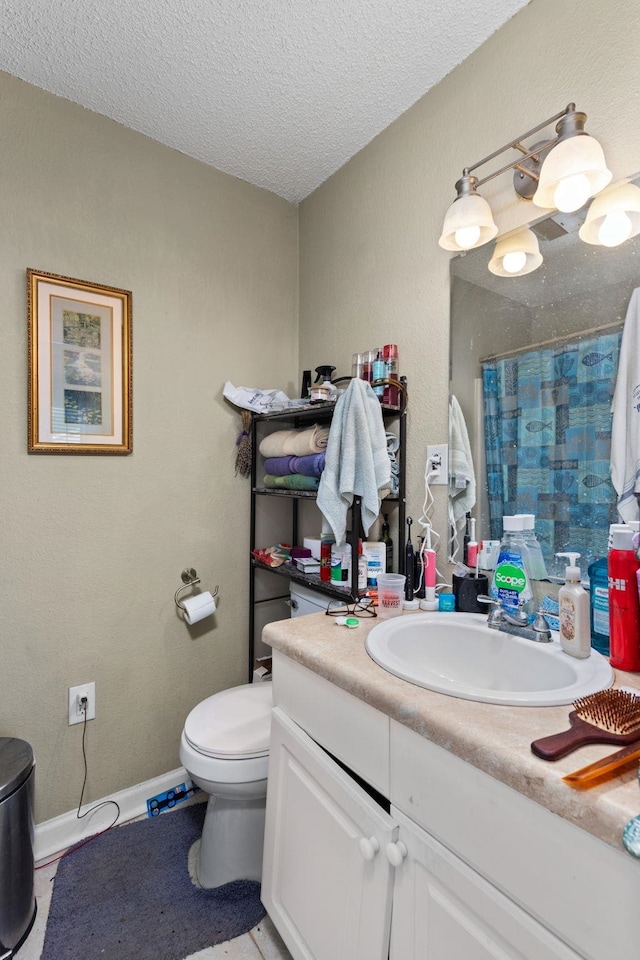 bathroom featuring vanity, a shower with shower curtain, baseboards, a textured ceiling, and toilet