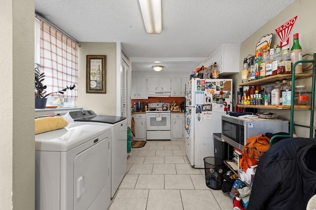 washroom with washer and dryer, a textured ceiling, laundry area, and light tile patterned floors