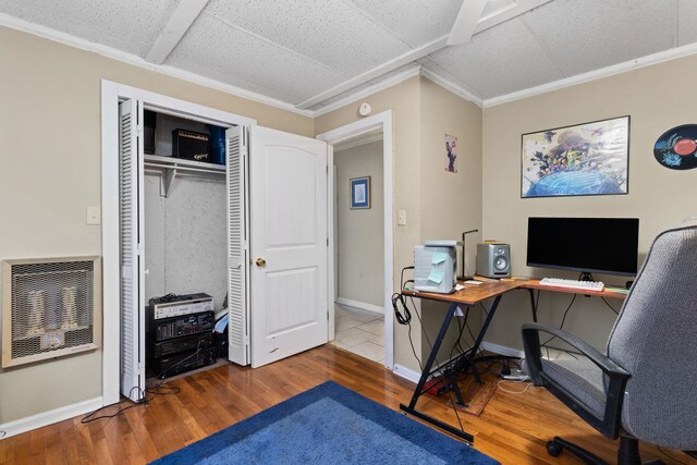 office space with heating unit, baseboards, wood finished floors, and ornamental molding