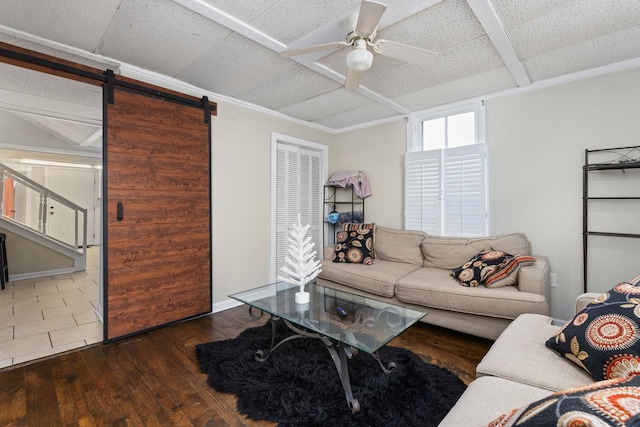 living room featuring a barn door, a ceiling fan, and hardwood / wood-style flooring