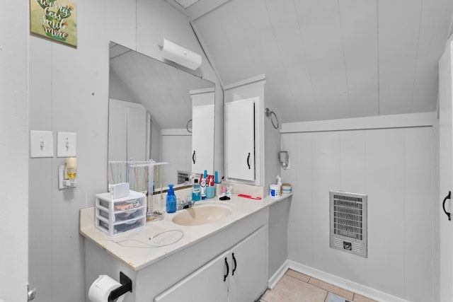 bathroom with heating unit, vanity, tile patterned flooring, and vaulted ceiling