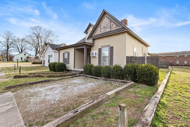 view of front of property with a chimney and fence