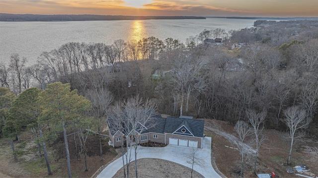 aerial view at dusk featuring a water view