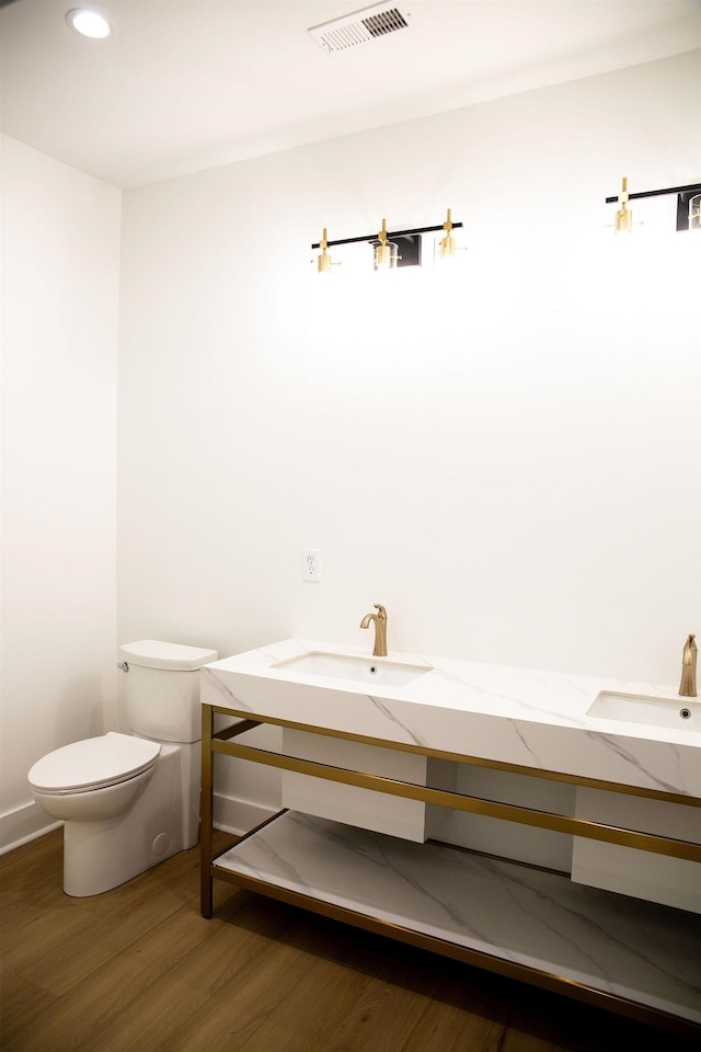 bathroom with vanity, toilet, and wood-type flooring