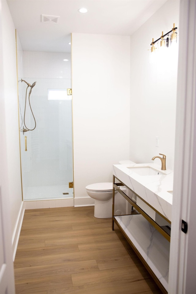 bathroom featuring walk in shower, toilet, vanity, and hardwood / wood-style flooring