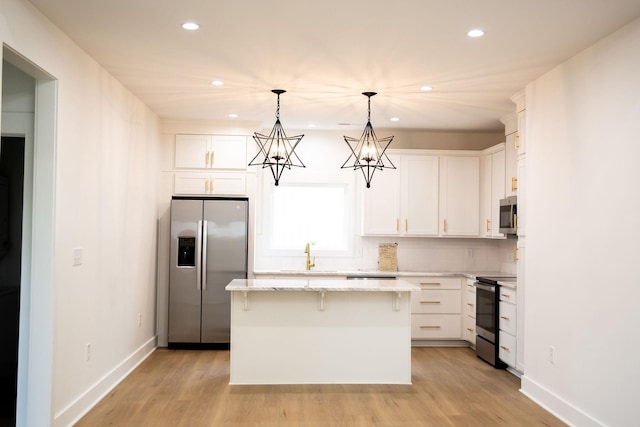 kitchen featuring white cabinetry, sink, pendant lighting, a kitchen island, and appliances with stainless steel finishes