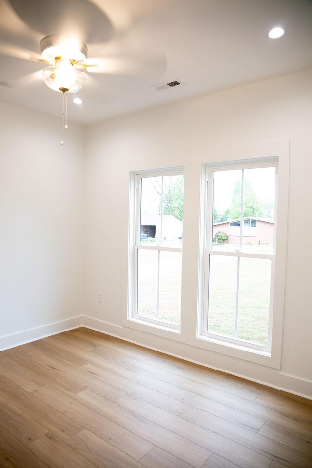 spare room with ceiling fan and light wood-type flooring