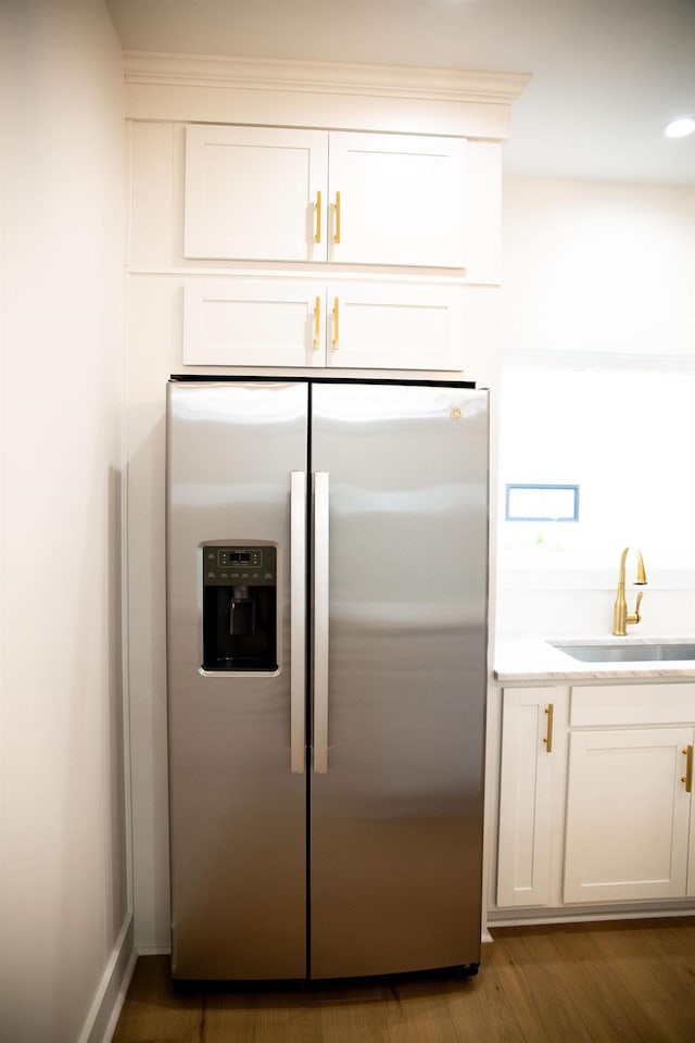 kitchen featuring white cabinetry, dark hardwood / wood-style flooring, stainless steel fridge, and sink