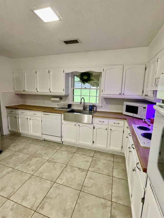  - kitchen featuring white appliances, white cabinetry, and light tile patterned floors