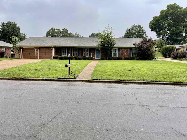  - ranch-style house featuring a front lawn, an attached garage, concrete driveway, and brick siding
