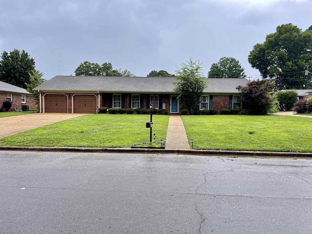 - ranch-style home featuring a garage, a front lawn, concrete driveway, and brick siding