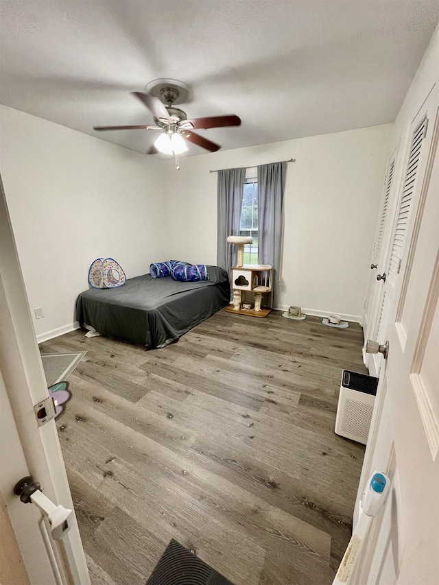  - bedroom featuring wood finished floors and a ceiling fan