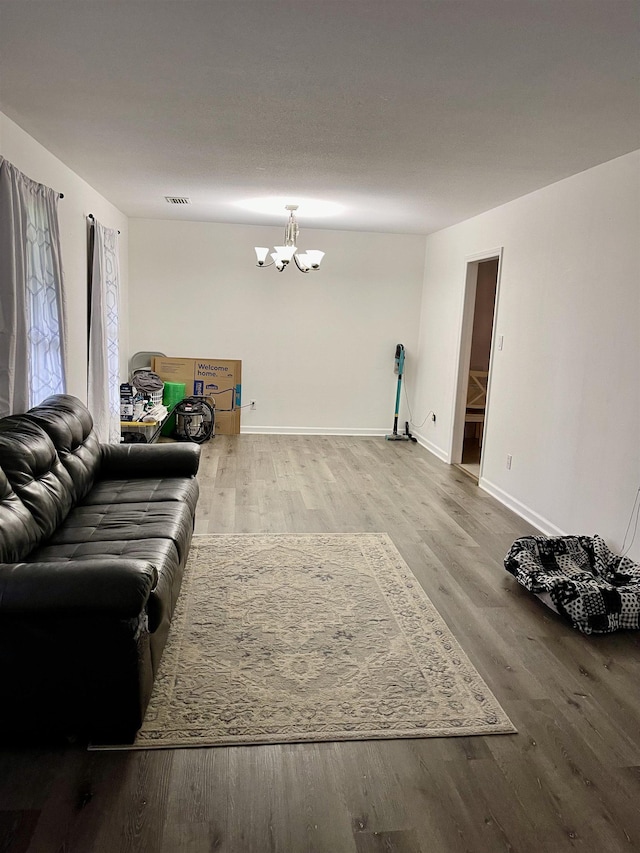  - living area featuring wood finished floors and a chandelier