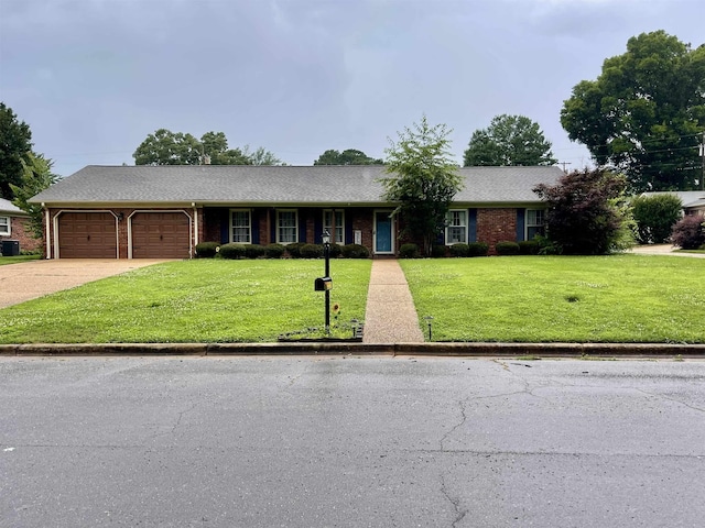 - ranch-style house featuring an attached garage, a front yard, driveway, brick siding, and roof with shingles