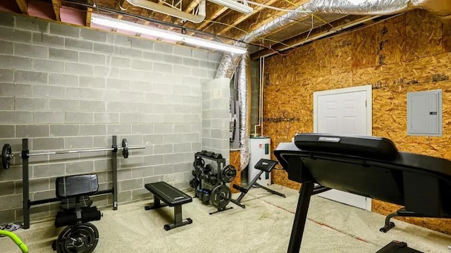 workout room with electric water heater, electric panel, and concrete block wall