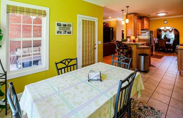 dining room with crown molding and light tile patterned floors