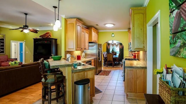 kitchen featuring stainless steel appliances, a breakfast bar, a peninsula, a sink, and open floor plan