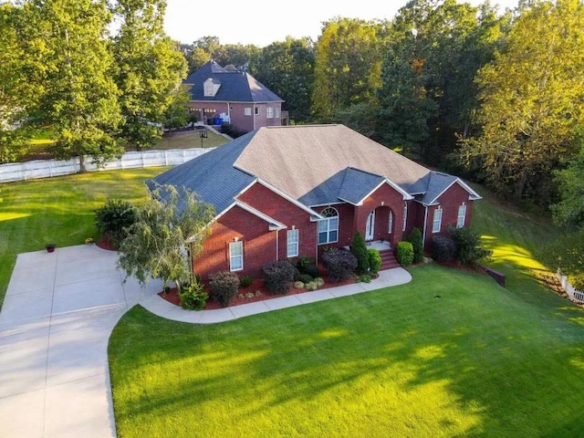 view of front of house featuring brick siding, fence, and a front yard