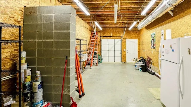 interior space with a garage and freestanding refrigerator