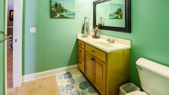 bathroom with tile patterned flooring, baseboards, vanity, and toilet