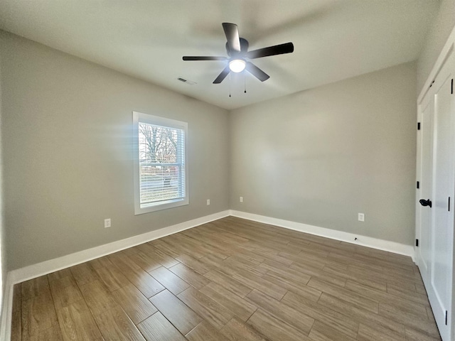 empty room with light wood-type flooring, visible vents, baseboards, and a ceiling fan