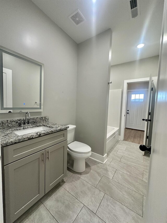 bathroom featuring toilet, baseboards, visible vents, and vanity