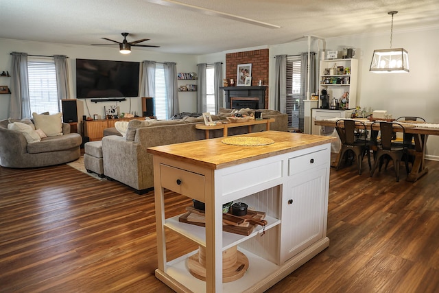 kitchen featuring white cabinets, butcher block countertops, open floor plan, hanging light fixtures, and open shelves