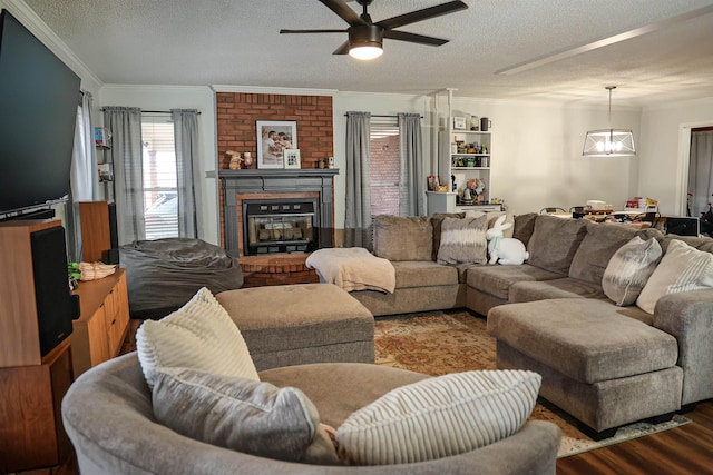 living area featuring a textured ceiling, a brick fireplace, and crown molding