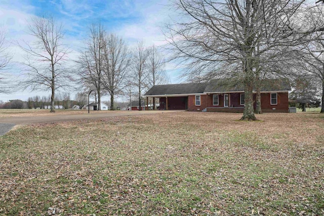 ranch-style home featuring an attached carport and a front yard