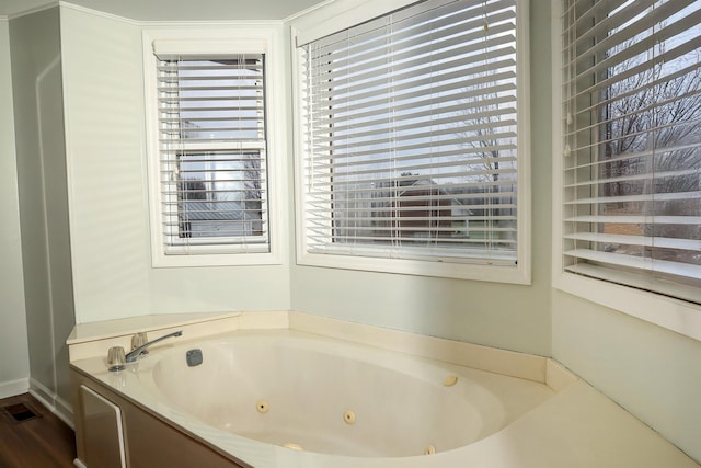 bathroom with a whirlpool tub and visible vents