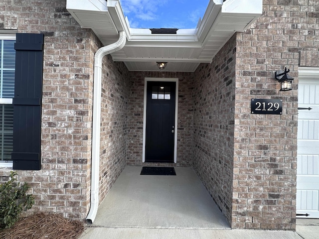 doorway to property featuring brick siding