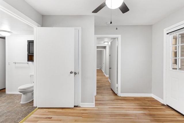 interior space featuring a closet, connected bathroom, ceiling fan, and light hardwood / wood-style flooring