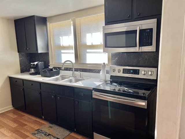 kitchen featuring decorative backsplash, sink, wood-type flooring, and appliances with stainless steel finishes