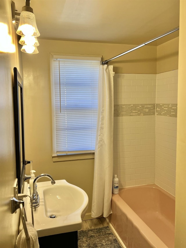 bathroom featuring wood-type flooring, vanity, and shower / tub combo with curtain