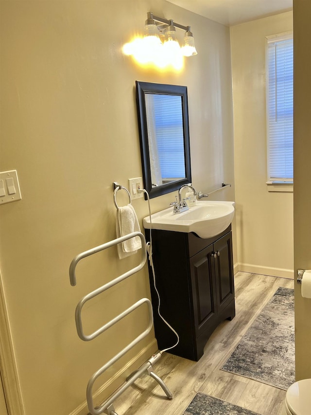 bathroom with hardwood / wood-style floors, vanity, and toilet